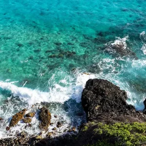 Looking down from a cliff into turquoise colored water off the Makapu'u Point coastline.
