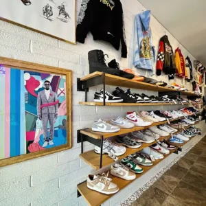 White brick wall with hoodies and shelves of collector sneakers.